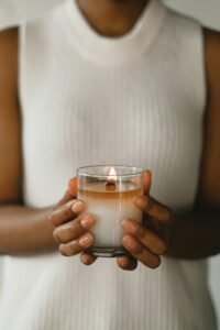 Una imagen relajante de una mujer sosteniendo una vela encendida, perfecta para promover la calma y la tranquilidad.